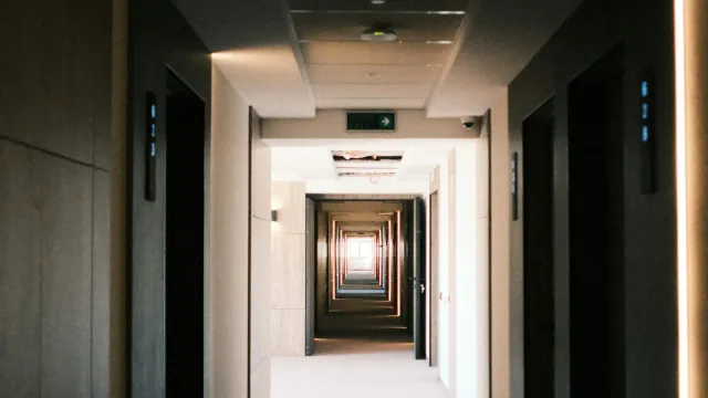 Gedimmter Hotelflur mit Zimmertüren – Escort buchen