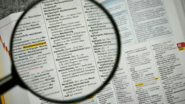 Lupe über einer Wörterbuchseite – Escort Begriffe verständlich erklärt